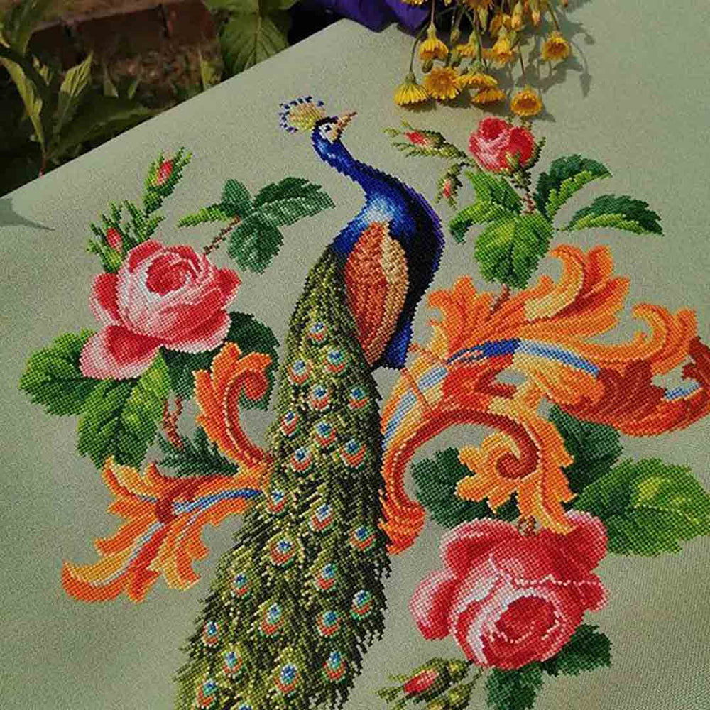 A stitched preview of the counted cross stitch pattern Peacock and Scrolling Roses by Antique Needlework Design