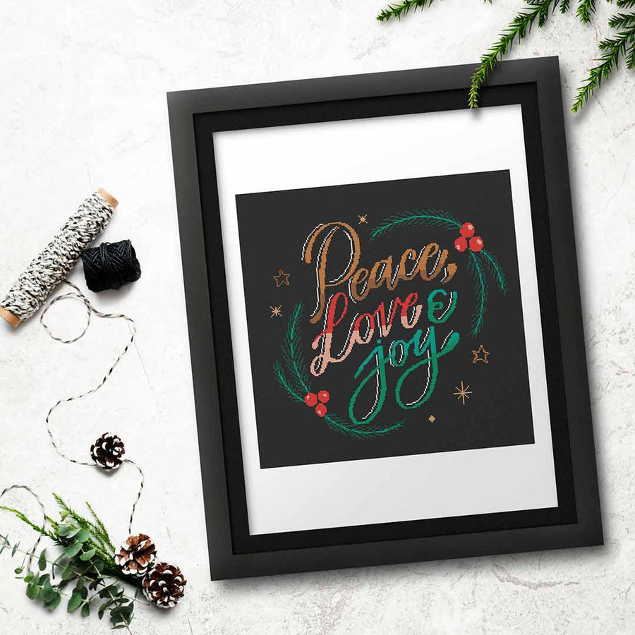 Stitched and framed preview of Peace Love Joy Counted Cross Stitch Pattern and Kit