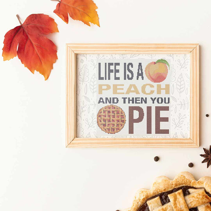 Stitched and framed preview of Peach Pie Counted Cross Stitch Pattern and Kit